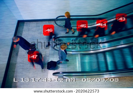 Security camera image of people on escalators Royalty-Free Stock Photo #2020622573