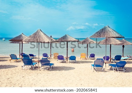 Wooden umbrellas and chairs at the beach. Selective focus on the front sun umbrellas