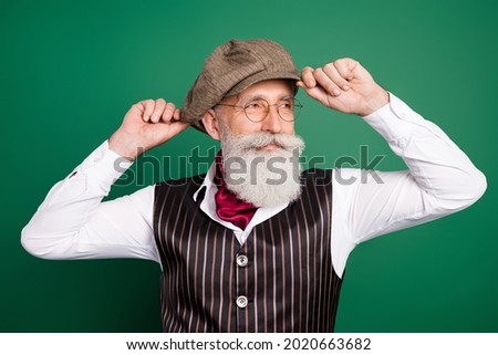 Photo of positive bearded detective look empty space wear hat eyewear striped suit scarf on green color background