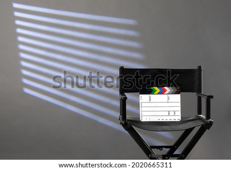 director's chair with clapperboard on gray background of photo studio