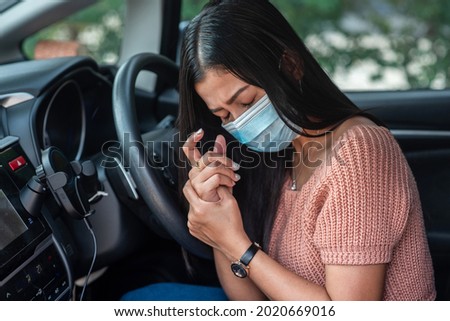 Asian girl bitch in the car A woman's hand with numbness and pain in the palm of the hand has pain and tingling in the nerve endings. which is a side effect of Guillain-Barre Syndrome after vaccination. 