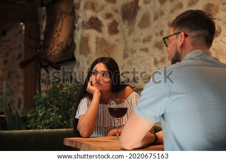 Young woman getting bored during date with man at cafe Royalty-Free Stock Photo #2020675163