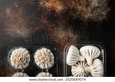 Uzbek Manti. Manti or manty dumplings, popular uzbek-asian dish set, in plastic tray, on old dark rustic background, top view flat lay, with copy space for text