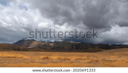 Grey clouds over fields and mountains in New Zealand