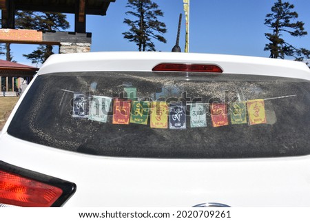 A closeup of colorful Tibetan Buddhist prayer flags hanging at the rear window of a car Royalty-Free Stock Photo #2020709261
