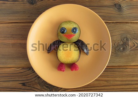 A funny baby bird made of fruit on a plate. Children's breakfast. A creative idea for decorating food for children.
