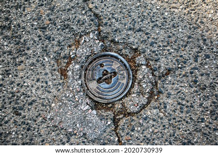 Close-up of a manhole cover, Hydrant in Gray gravel stones for the construction industry. Geometric shape Background. Rusty cover on street. Road construction concept