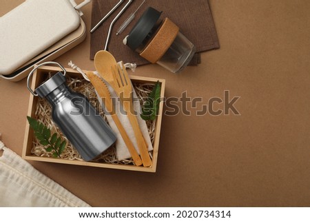 Flat lay composition with eco friendly products on brown background, space for text