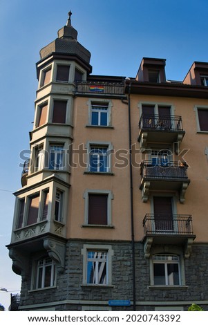 A vertical shot of a vintage building and LGBT flag on top of it