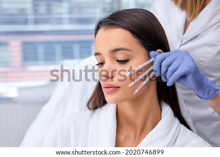Side view close-up photo of young brunette female came to cosmetologist to get PDO thread, Thread Lifting procedure. Aesthetic beauty anti aging, face lifting surgery. Chossing the best thread Royalty-Free Stock Photo #2020746899