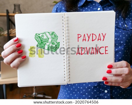Financial concept meaning PAYDAY ADVANCE with sign on the sheet. 
