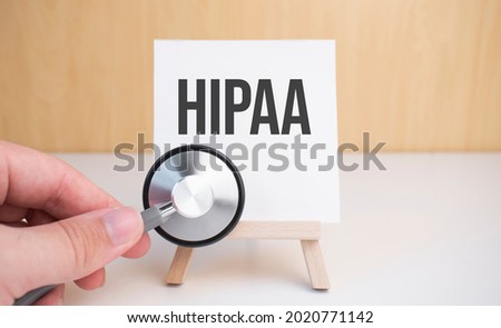 Doctor holds stethoscope and easel with text HIPAA