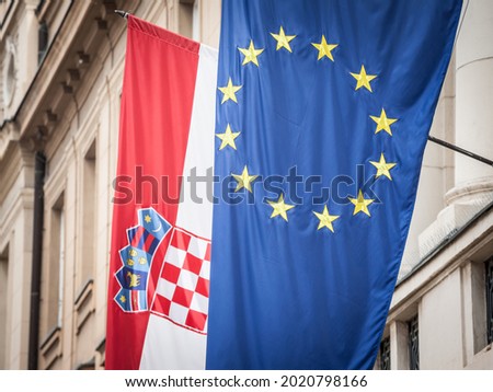 Croatian and European flags waiving in the air with a building in background. Croatia is the youngest country that joined the European Union in 2013.

 Royalty-Free Stock Photo #2020798166