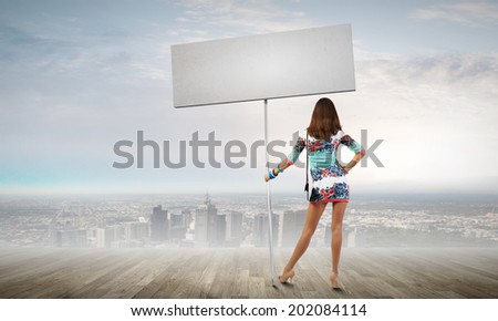 Rear view of young attractive woman with blank white banner