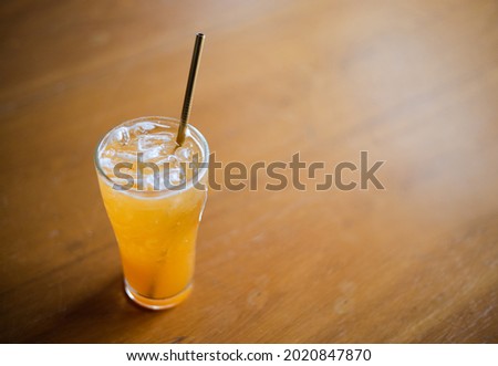 Orange juice in a glasss on wooden table in the library. Fresh orange juice for a good health. copy space.