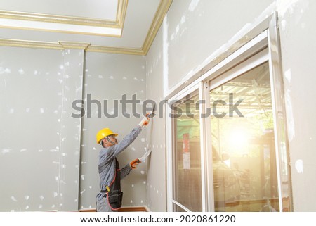 Putty plaster on the wall,Craftsman working with plaster gypsum ceiling for interior build gypsum board ceiling Royalty-Free Stock Photo #2020861220