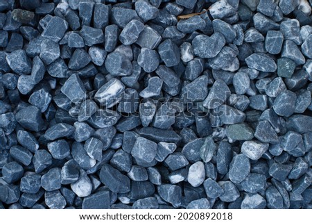 Smooth dark blue stones, decorative element for garden and landscape. Textured stone background top view, outdoors.