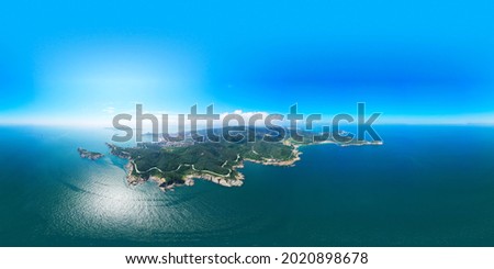 Aerial photography of blue sky and sea; a small green island in the sea