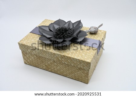 Beautiful gift packaging made from recycled natural materials that are woven, with flowers on it.