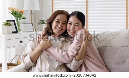 Attractive beautiful mum sit at cozy sofa couch living room in family moment grown up child kid look camera celebrate joy good warm time relationship with retired overjoy lady girl life insurance.