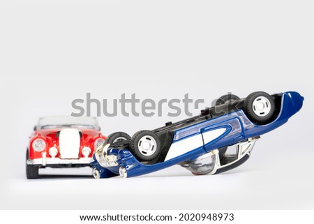 Cars crashed and overturned. Red and blue toy cars are made of steel. on isolated white background.