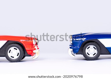 Red and blue cars parked facing each other. On isolated white background with shadow.
