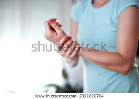 Woman with hand and arm pain at home.