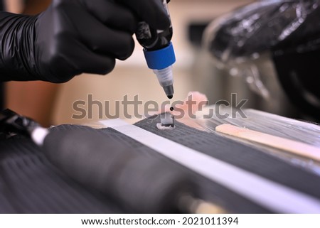 Woman tattoo artist pouring ink. Art and design concept. Close up