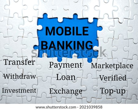 Selective focus.Text MOBILE BANKING writing on blue background with jigsaw puzzle.Business mobile banking concept.
