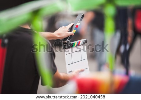 Filming on location. Man holding a clapperboard in front of the camera, the filming process. Scene on location Royalty-Free Stock Photo #2021040458