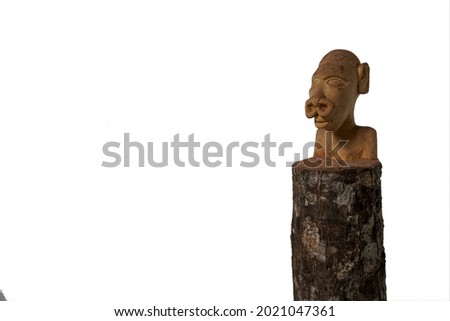 The photo on a white isolated background shows a statue that is handcrafted by indigenous tribes made of soft wood                           