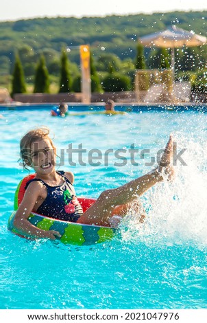 A child in a circle swims in the pool. Selective focus. Kid.