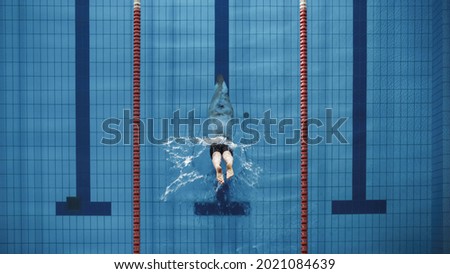 Aerial Top View Male Swimmer Jumping, Diving into Swimming Pool. Professional Athlete Winning World Championship. Top Down View. Royalty-Free Stock Photo #2021084639