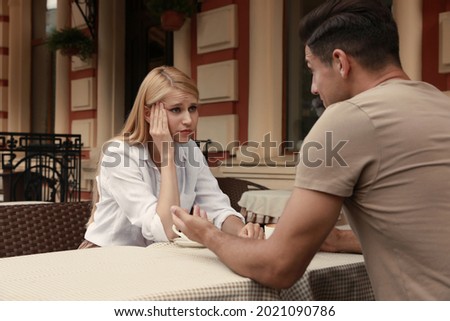 Young woman having boring date with talkative man in outdoor cafe Royalty-Free Stock Photo #2021090786