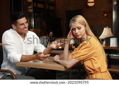 Young woman having boring date with talkative man in cafe Royalty-Free Stock Photo #2021090795