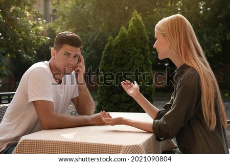 Man having boring date with talkative woman in outdoor cafe Royalty-Free Stock Photo #2021090804