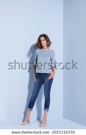 Editorial photography, clothing catalogue, fashion. Blue background. Business woman.