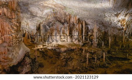 Wonderful picture of passage for tourists in big cavern with huge stalactites, stalagmites and stalagnates in Postojna cave, Slovenia, Europe. 