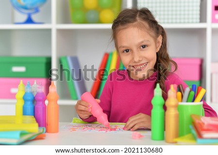 Close up porait of cute girl drawing picture at home
