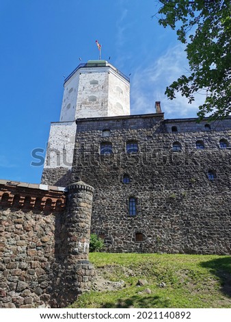 The walls of Vyborg Castle and the Tower of St. Olaf in the city of Vyborg against the blue sky.