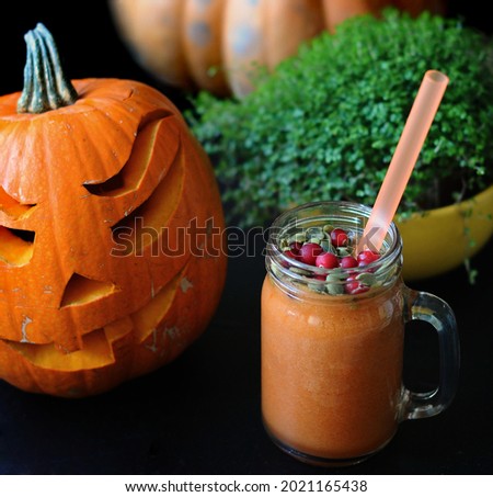 pumpkin smoothie with cranberries and halloween jack o lantern