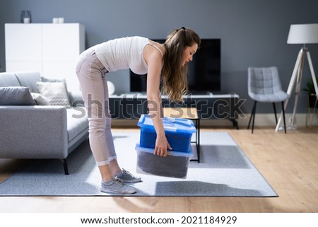 Incorrect Box Lifting Posture. Heavy Weight Lift Incorrect Box Lifting Posture. Heavy Weight Lift Royalty-Free Stock Photo #2021184929