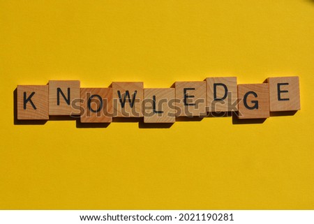 Knowledge, word in wooden alphabet letters isolated on bright yellow background