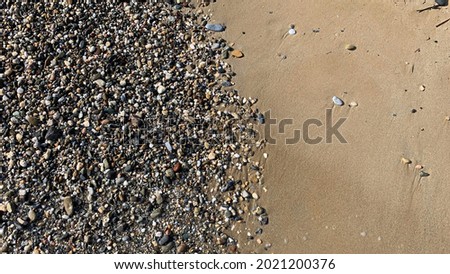 Beach sand with small stones in beautiful coast