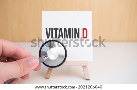 Doctor holds stethoscope and easel with text Vitamin d