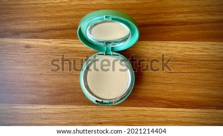 Women powder make up on the brown light wooden texture table