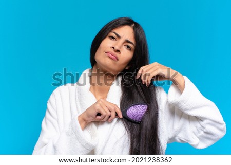 young hispanic woman with a hair brush.
