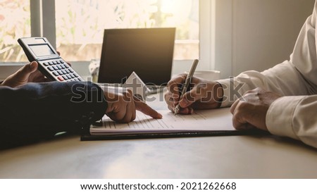 businessman holding a ballpoint pen writing on a sheet of paper an agreement fills out a mortgage loan application form template finance investment concept