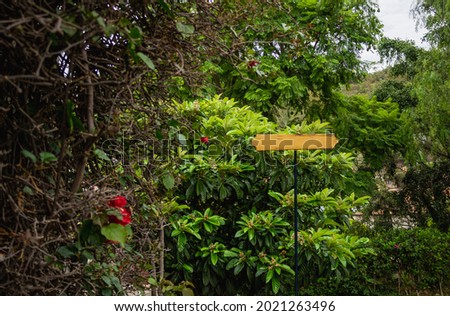Blank sign ready to edit and put a message with address surrounded by a dense vegetation very natural and green ideal for advertising small spaces or put as a tourist guide.