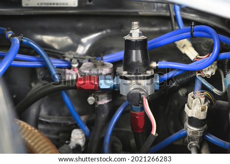 Close-up of car fuel pressure regulators in the engine bay. Royalty-Free Stock Photo #2021266283